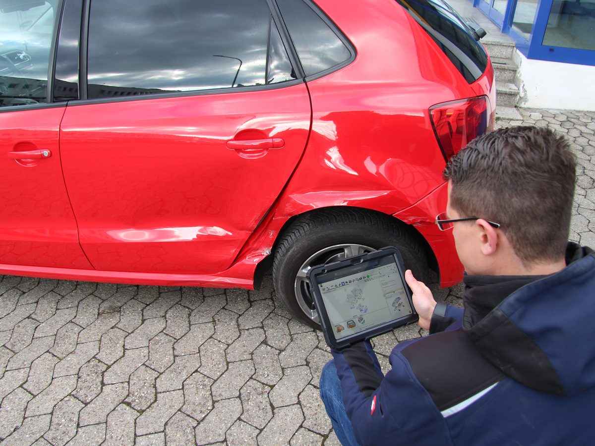 Kfz-Sachverständiger dokumentiert einen Fahrzeugschaden digital am Tablet